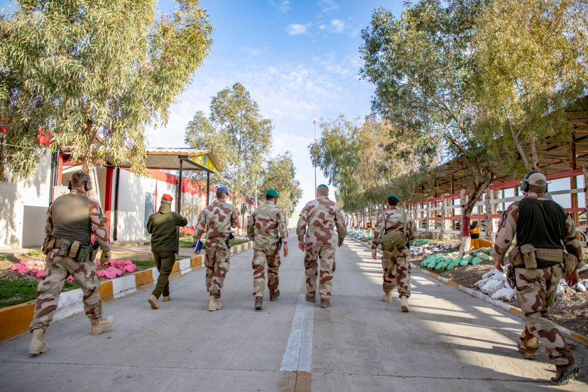 En gruppe soldater går langs en vei i et fremmed land.
